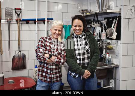 Portrait des travailleuses souriantes debout dans la brasserie Banque D'Images