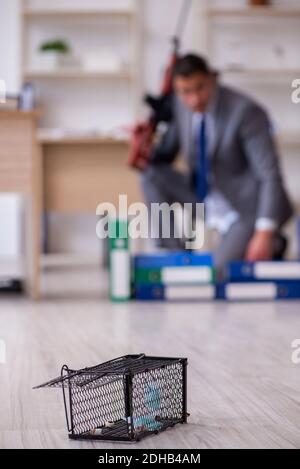 Jeune homme et mousetrap au bureau Banque D'Images