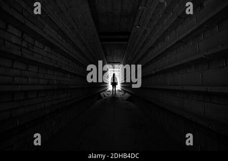 Personne debout dans la lumière au bout du tunnel, silhouette Banque D'Images