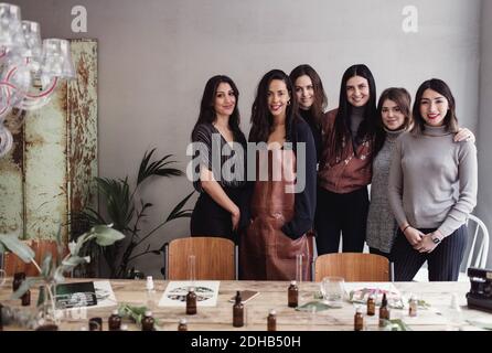 Portrait de collègues féminins multiethniques confiants debout contre le mur à atelier parfum Banque D'Images
