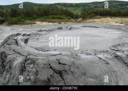 Cratère bouillant d'un volcan de boue. Vue rapprochée sur l'explosion d'une bulle de gaz dans un cratère de volcan de boue. Volcan de boue à Paclele mari, près de Buzau, Roumanie. Banque D'Images