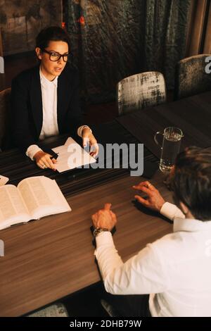 Vue en grand angle du client discutant des problèmes avec une avocate féminine en réunion Banque D'Images