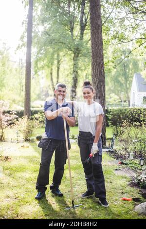 Portrait complet d'une femme stagiaire souriante debout à la main sur l'épaule de l'instructeur dans le jardin Banque D'Images