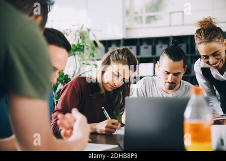 Professionnels multiethniques, hommes et femmes, travaillant à table dans la création bureau Banque D'Images