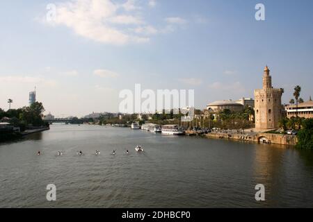 Vue sur la ville de Séville Espagne sur la rivière Guadalquiver avec canoës pagayant dans une rangée de l'autre côté de la rivière sur un Chaud avril à Pâques 2014 Banque D'Images