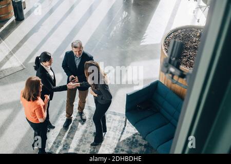 Vue en grand angle des collègues qui s'intéressent à l'accueil des femmes d'affaires bureau Banque D'Images