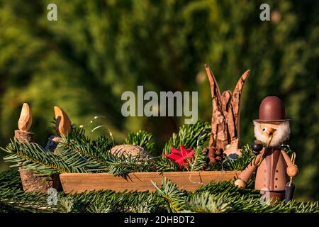 Un bol avec des éléments décoratifs comme un fumeur, un ange et une bougie en bois pour Noël Banque D'Images