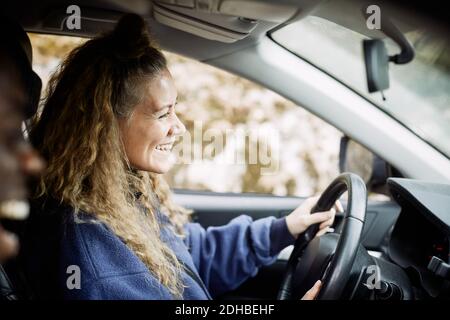 Vue latérale d'une jeune femme heureuse en voiture Banque D'Images