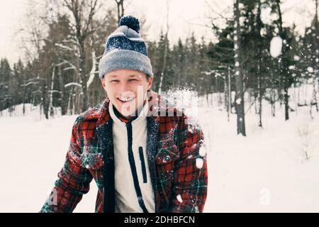 Portrait d'un homme mi-adulte heureux en vêtement chaud champ recouvert de neige Banque D'Images