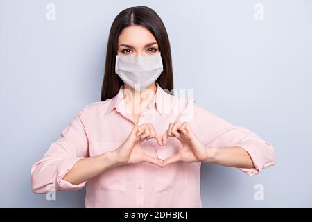 Portrait d'une jolie fille en bonne santé portant un masque de sécurité en forme de coeur prévention des maladies chroniques isolées sur fond gris Banque D'Images