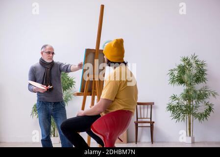 Vieux portraitiste et jeune modèle masculin Banque D'Images
