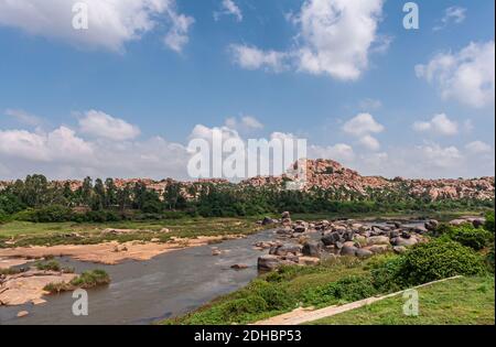 Hampi, Karnataka, Inde - 4 novembre 2013 : rivière Tungabhadra juste au nord du complexe du temple de Viriupaksha. Gros plan avec blocs noircis, ceinture verte, Banque D'Images