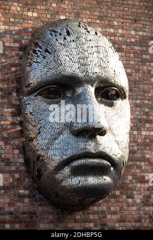 Une sculpture à face métallique conçue par Rick Kirby montée sur le côté du Drill Hall , Lincoln, Angleterre, Royaume-Uni. Banque D'Images