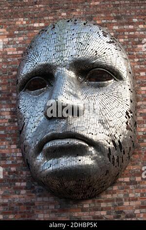 Une sculpture à face métallique conçue par Rick Kirby montée sur le côté du Drill Hall , Lincoln, Angleterre, Royaume-Uni. Banque D'Images
