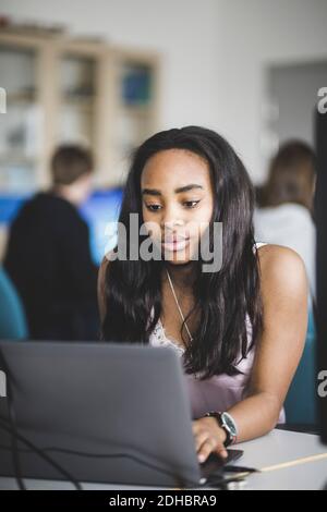 Une femme sûre d'elle-même utilise un ordinateur portable à son bureau salle de classe Banque D'Images