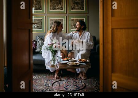 Un couple heureux dans des peignoirs dans la chambre d'hôtel Banque D'Images