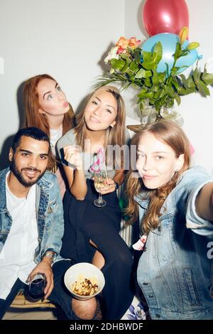 Portrait de jeunes heureux multi-ethniques amis appréciant la fête à l'appartement Banque D'Images