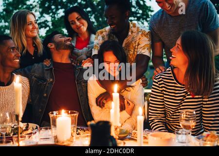 Des amis masculins et féminins de bonne humeur, issus de diverses ethnies, apprécient le dîner Banque D'Images