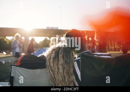 Vue arrière d'un couple aimant en train de profiter du festival de musique contre ciel Banque D'Images
