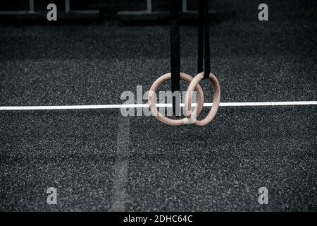 Vue rapprochée en petit angle de l'anneau de gymnastique suspendu dans la salle de sport. Élément d'équipement de sport pour la gymnastique. Concept d'entraînement en ligne Banque D'Images