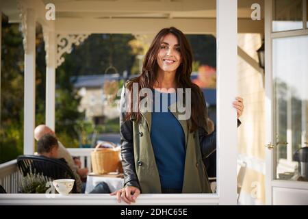 Portrait d'une femme mûre souriante et confiante debout sous le porche Banque D'Images