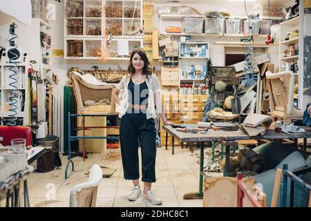 Portrait d'une femme confiante travaillant sur le sellerie debout dans l'atelier Banque D'Images
