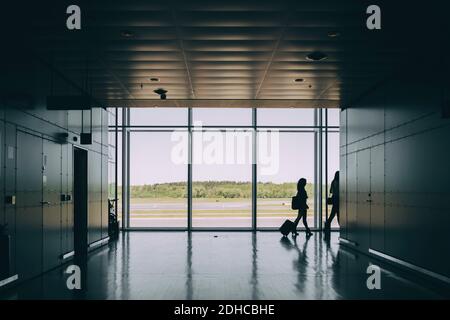 Une silhouette parfaite pour les collègues d'affaires qui marchent dans le couloir à l'aéroport Banque D'Images