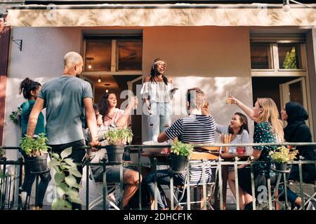 Amis multi-ethniques appréciant sur le balcon pendant la fête Banque D'Images
