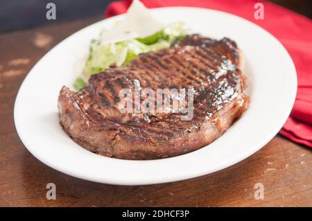 épais steak de ribeye poêlé rare sur un grill en fonte Banque D'Images