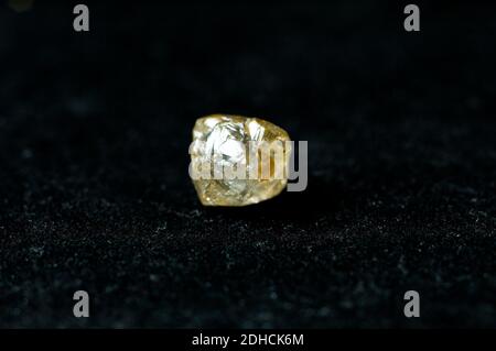 diamant jaune non coupé sur fond noir Banque D'Images