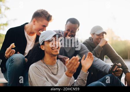 Des amis heureux en train de regarder leur smartphone au parc Banque D'Images