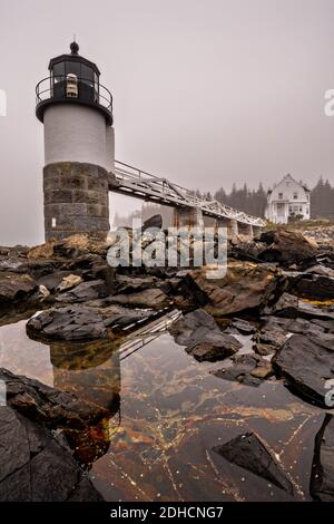 Le brouillard descend au-dessus du phare de Marshall point près de Port Clyde, Maine. Le phare actuel a été construit en 1832 sur un point de terre rocheux près de l'embouchure du port de Port Clyde et a été présenté dans le film majeur Forrest Gump. Banque D'Images