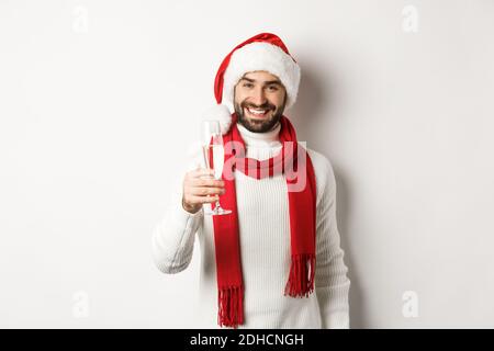Concept de fête de Noël et de vacances. Beau jeune homme avec barbe, faire un toast le jour de l'an, tenant un verre de champagne Banque D'Images