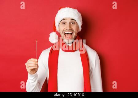 Concept de noël, de vacances d'hiver et de célébration. Gros plan d'un beau bonnet et d'une écharpe de père noël heureux, s'amuser sur le nouveau Banque D'Images