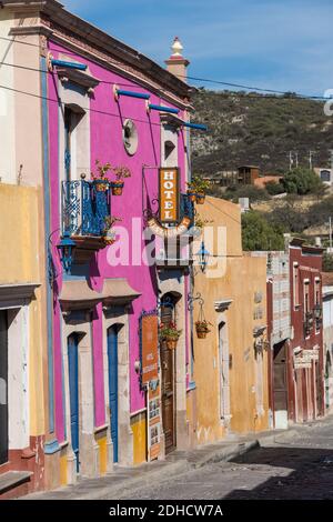 L'hôtel Centenario Centro, aux couleurs vives, se trouve dans le magnifique village colonial de Bernal, Queretaro, au Mexique. Bernal est une ville coloniale pittoresque connue pour la Pena de Bernal, un monolithe géant qui domine le petit village est le troisième plus haut de la planète. Banque D'Images