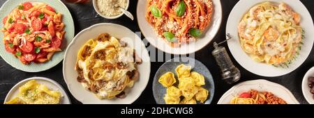 Panorama sur la variété des pâtes. Pâtes de poulet, de champignons, de légumes, de fruits de mer et de viande. Tiré du dessus dans un plat, poser sur un fond noir Banque D'Images