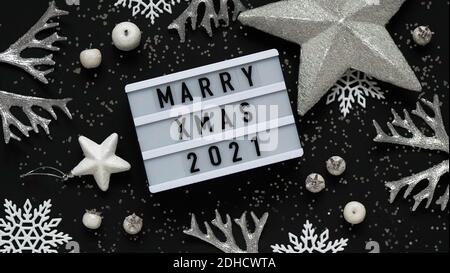 Concept de mariage bannière de Noël.Tableau blanc avec texte lettrage se marient Noël 2021 entre Noël blanc argent décor, boules, baies, étoiles et blanc Banque D'Images