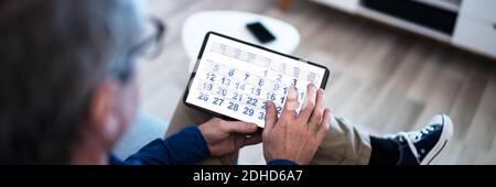 Homme utilisant l'Agenda du calendrier sur un ordinateur tablette Banque D'Images