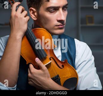 Jeune musicien man à jouer du violon à la maison Banque D'Images