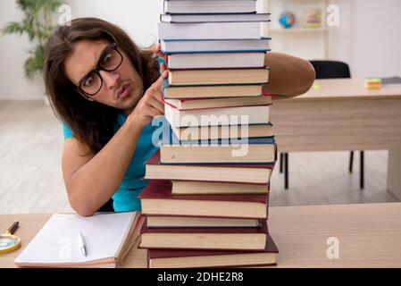 Jeune étudiant et beaucoup de livres dans le classe Banque D'Images