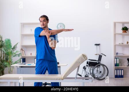 Jeune homme médecin physiothérapeute faisant des exercices de sport Banque D'Images