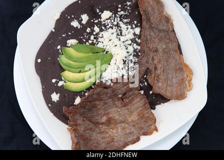 Vue en hauteur du steak de carne asada parfaitement préparé sur le grill avec des haricots et de l'avocat sur le dessus. Banque D'Images