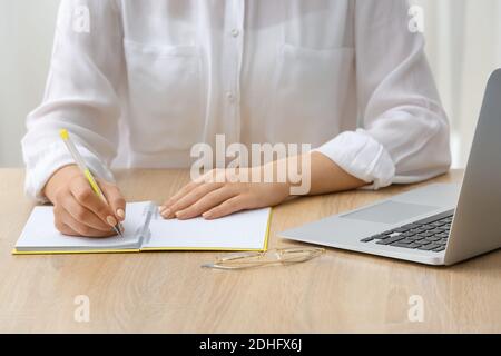 Femme écrivant dans un bloc-notes avec un stylo Banque D'Images