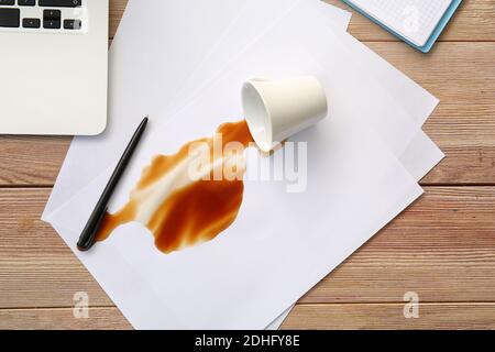 Articles de papeterie, gobelet renversé et café renversé sur la table Banque D'Images