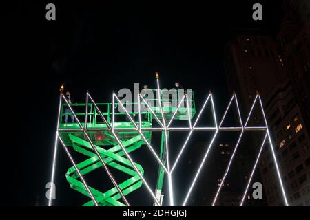 New York, NY - 10 décembre 2020 : le rabbin Shmuel Butman et les membres de l'organisation de jeunesse Lubavitch ont éclairé la menorah pour marquer la première nuit de Hanukkah sur Pulitzer Fountain plaza Banque D'Images