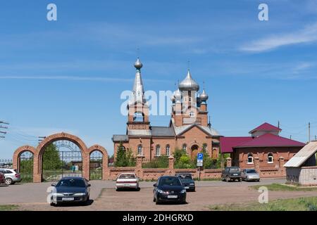 Église de l'Archange Michael avec des voitures garées devant elle, un jour d'été ensoleillé dans le village de Shira. Khakassia. Russie. Banque D'Images