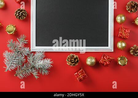 Cadre du nouvel an avec des jouets, des branches de sapin et des cadeaux du nouvel an dans un environnement sur fond rouge. Carte de vœux avec Noël, nouvel an avec gratuit Banque D'Images