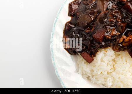 Riz Jjajang dans un plat sur fond blanc Banque D'Images