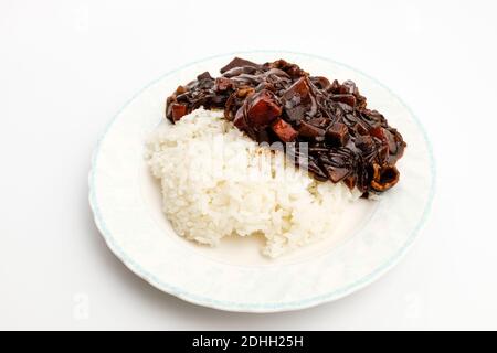 Riz Jjajang dans un plat sur fond blanc Banque D'Images