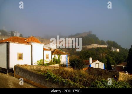 Vue de la vieille partie d'Obidos, Portugal au début matin brumeux. Banque D'Images